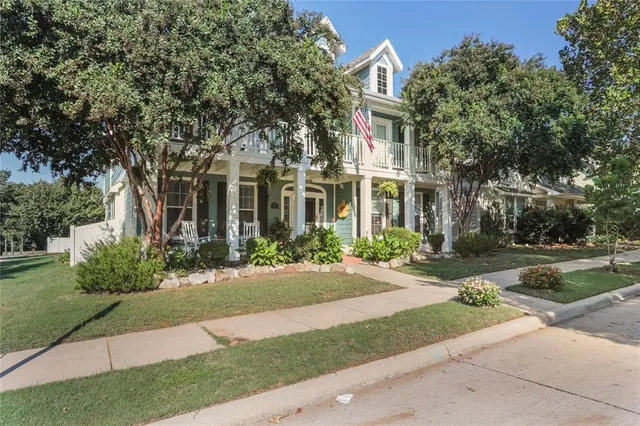 a front view of a house with a yard and potted plants