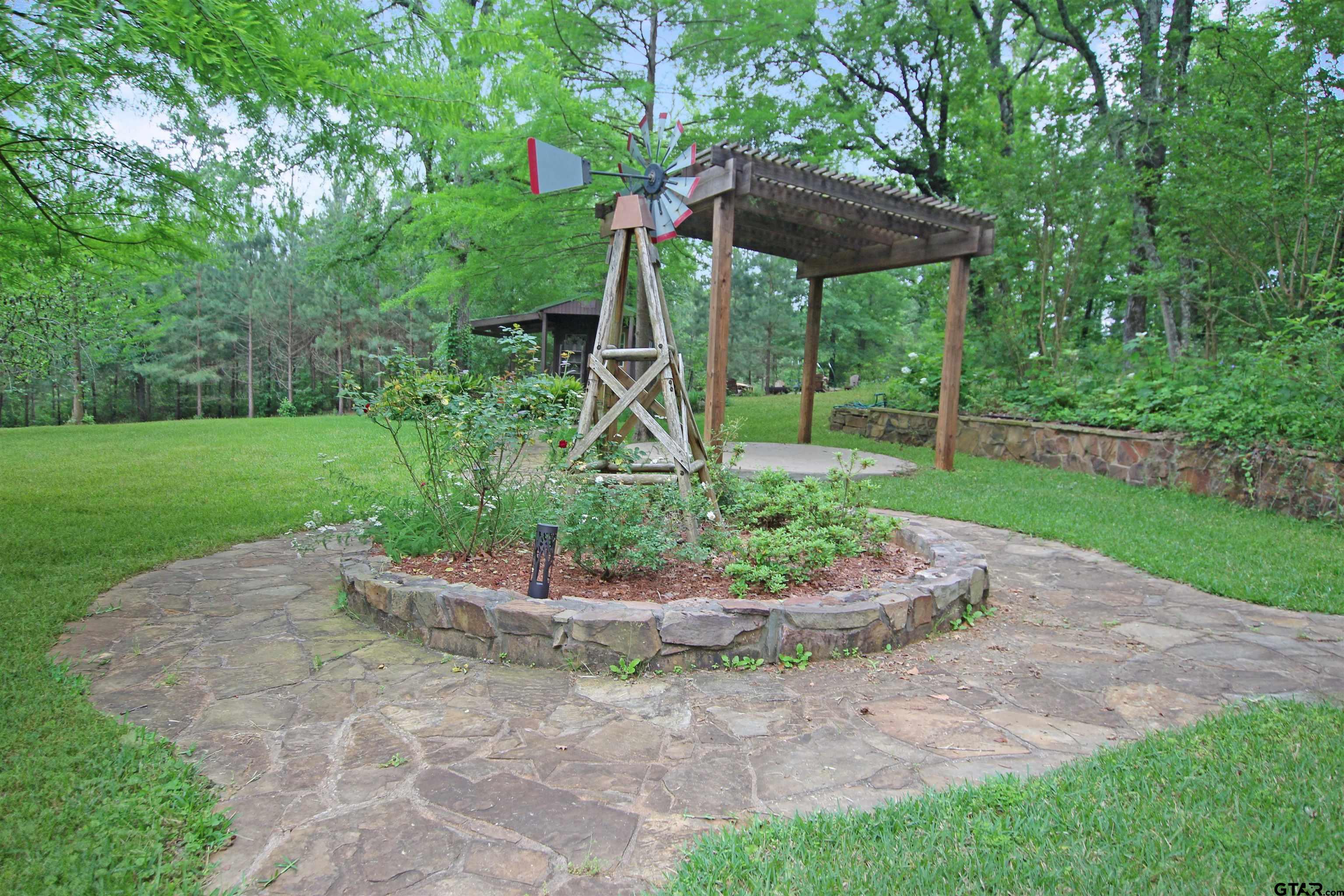782 Rosie Wady Road Gladewater, TX 75647 - Photo 39 of 48 a view of a backyard with table and chairs under an umbrella