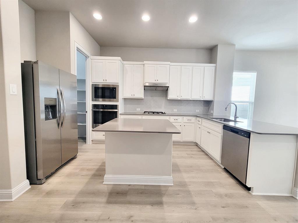 601 C-Bar Ranch Trail, Unit 14 Cedar Park, TX 78613 - Photo 5 of 22 a large kitchen with cabinets stainless steel appliances and a counter top