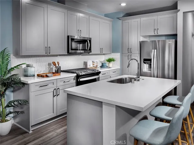 a kitchen with stainless steel appliances granite countertop a sink a stove and a refrigerator