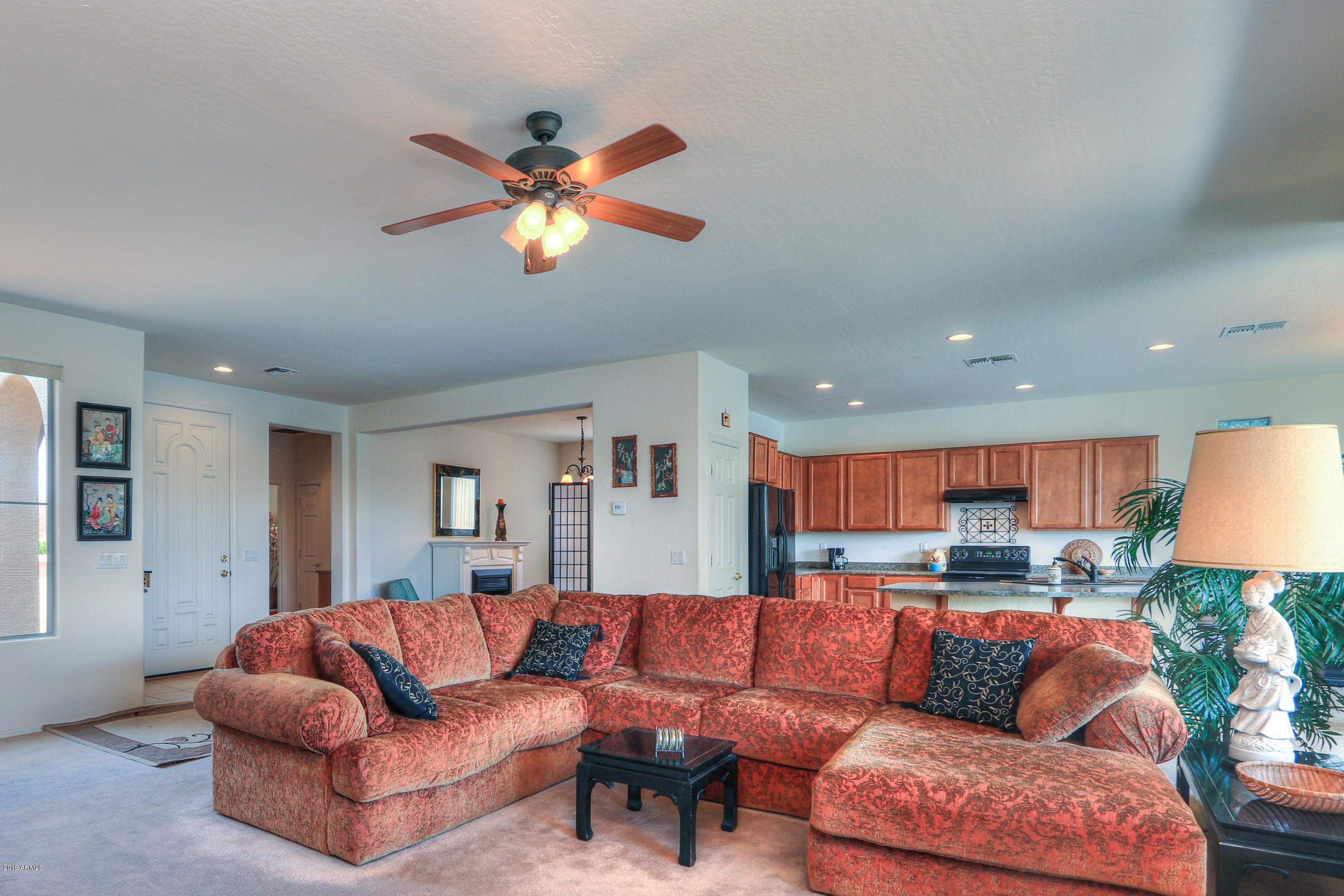 42485 Abbey Road Maricopa, AZ 85138 - Photo 13 of 74 a living room with furniture a couch and a chandelier