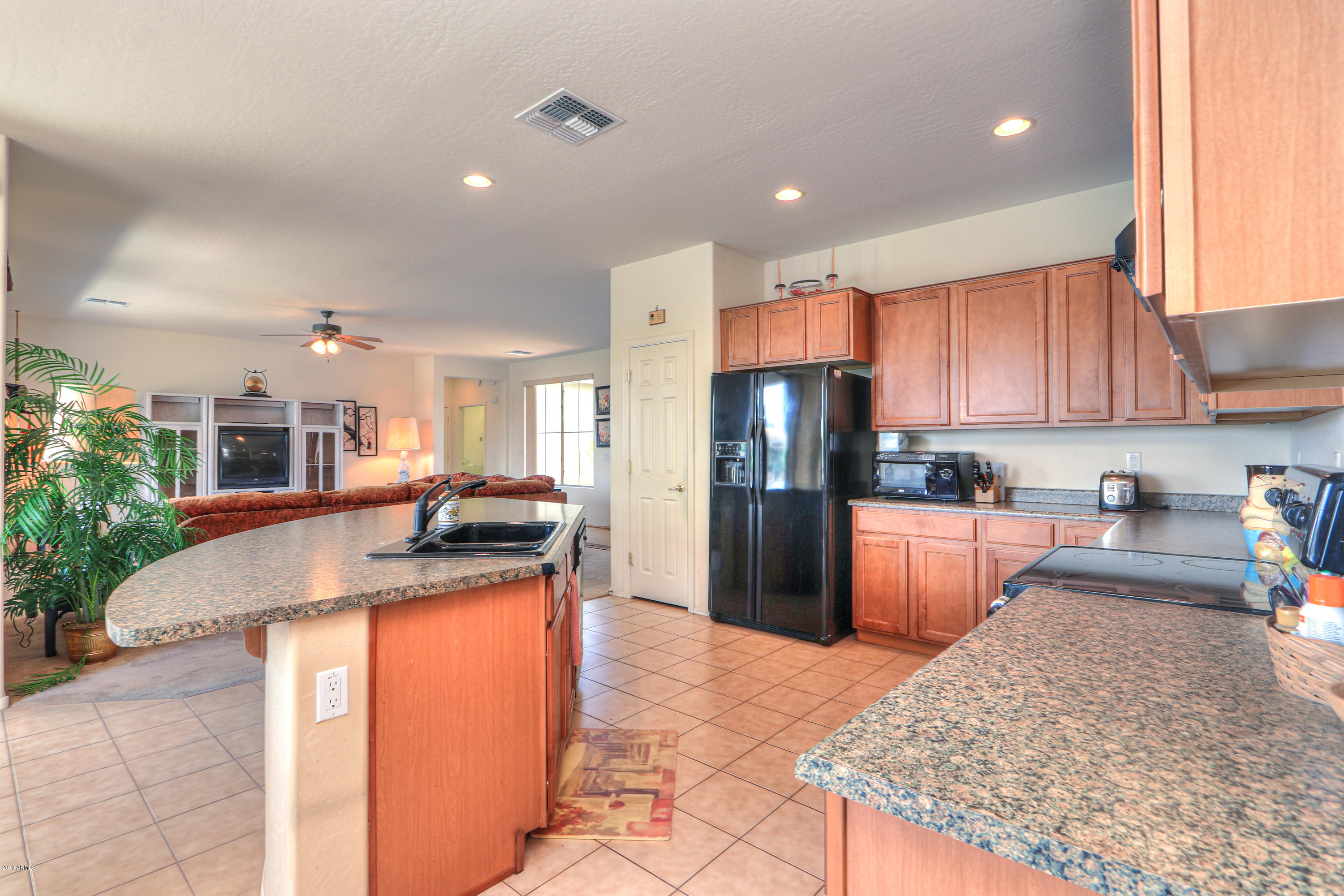42485 Abbey Road Maricopa, AZ 85138 - Photo 16 of 74 a kitchen with stainless steel appliances granite countertop a sink refrigerator and cabinets