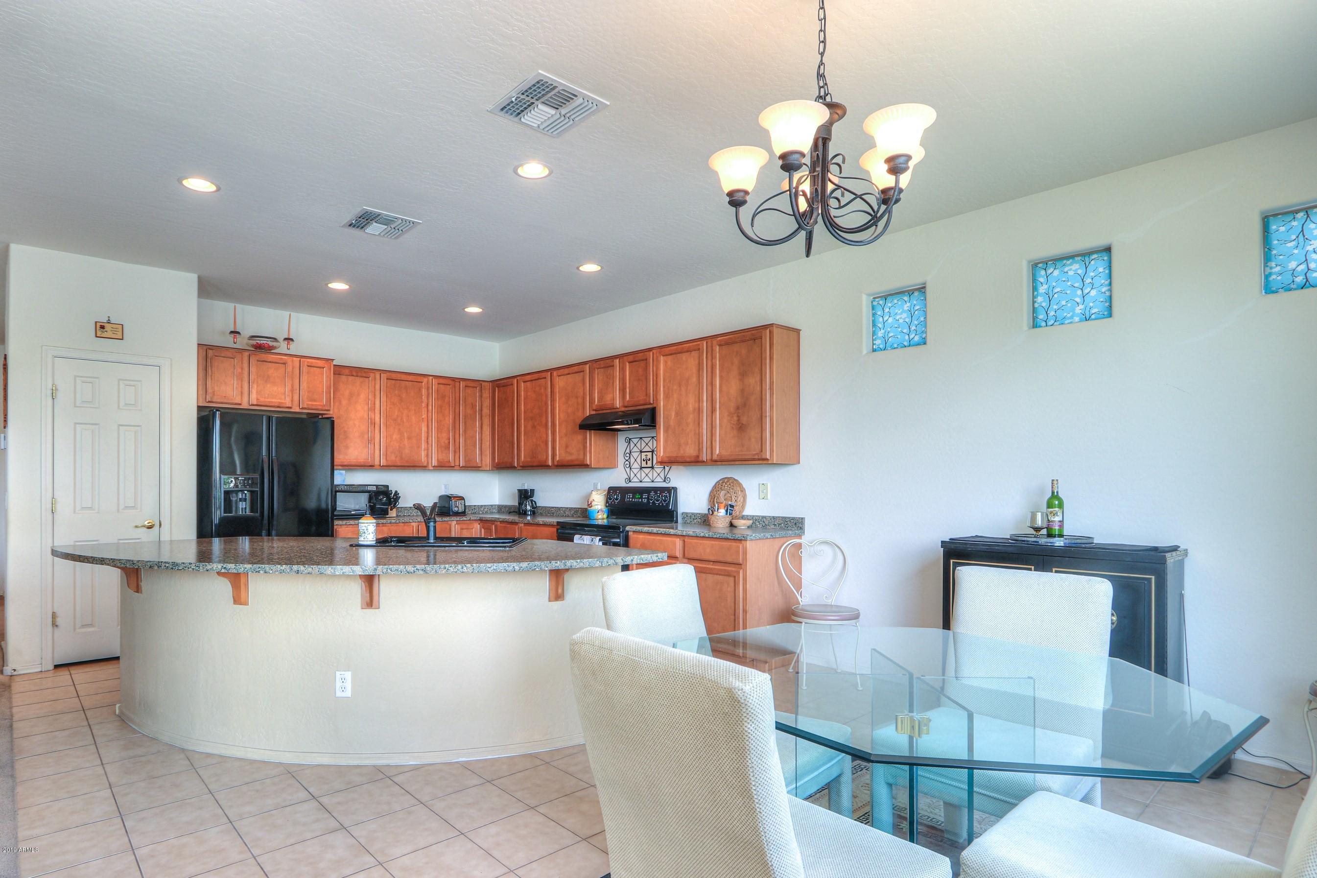 42485 Abbey Road Maricopa, AZ 85138 - Photo 22 of 74 a kitchen with kitchen island a white counter top space a sink and appliances