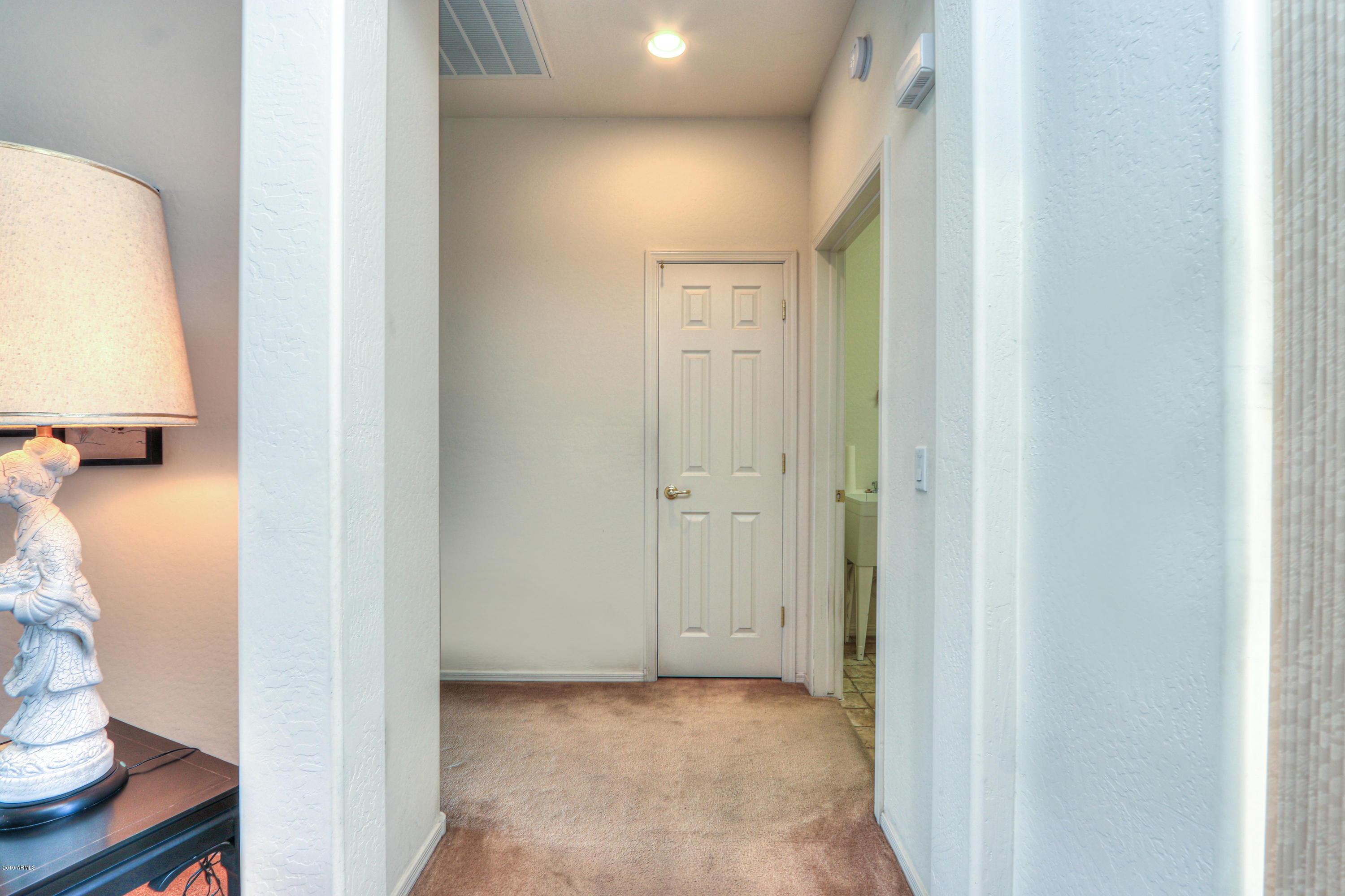 42485 Abbey Road Maricopa, AZ 85138 - Photo 26 of 74 a view of a hallway with wooden floor and a bathroom