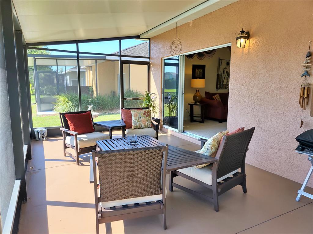 11997 Tempest Harbor Loop Venice, FL 34292 - Photo 13 of 52 a living room with furniture and a floor to ceiling window