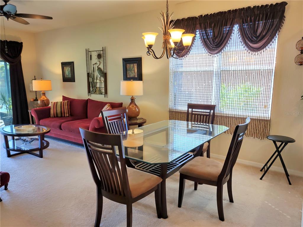 11997 Tempest Harbor Loop Venice, FL 34292 - Photo 19 of 52 a dining room with furniture a chandelier and wooden floor