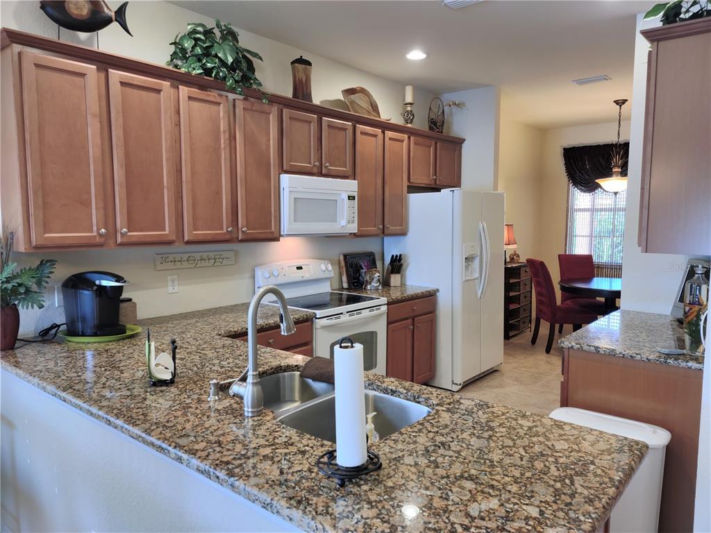 11997 Tempest Harbor Loop Venice, FL 34292 - Photo 20 of 52 a kitchen with stainless steel appliances granite countertop a refrigerator sink and cabinets