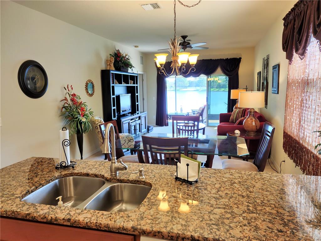 11997 Tempest Harbor Loop Venice, FL 34292 - Photo 26 of 52 a kitchen with a faucet a chandelier and living room view
