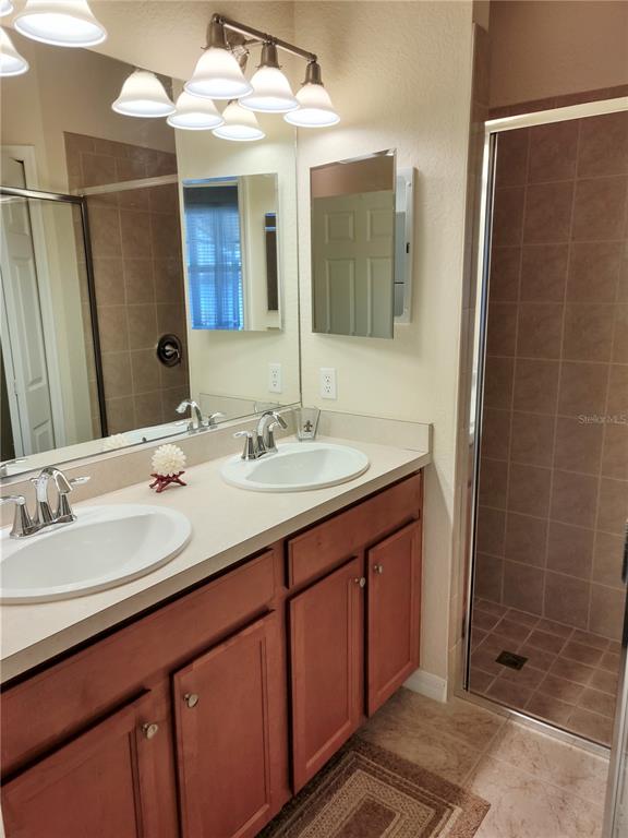 11997 Tempest Harbor Loop Venice, FL 34292 - Photo 33 of 52 a bathroom with a double vanity sink mirror and shower