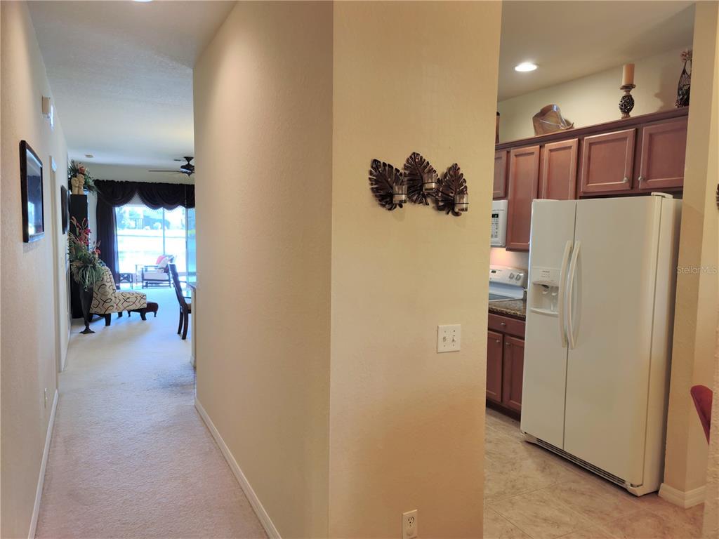 11997 Tempest Harbor Loop Venice, FL 34292 - Photo 6 of 52 a view of a hallway with a refrigerator and a refrigerator