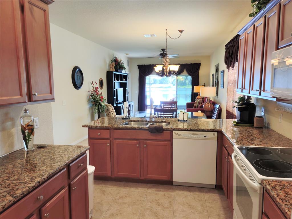 11997 Tempest Harbor Loop Venice, FL 34292 - Photo 7 of 52 a kitchen with stainless steel appliances granite countertop a sink stove and cabinets