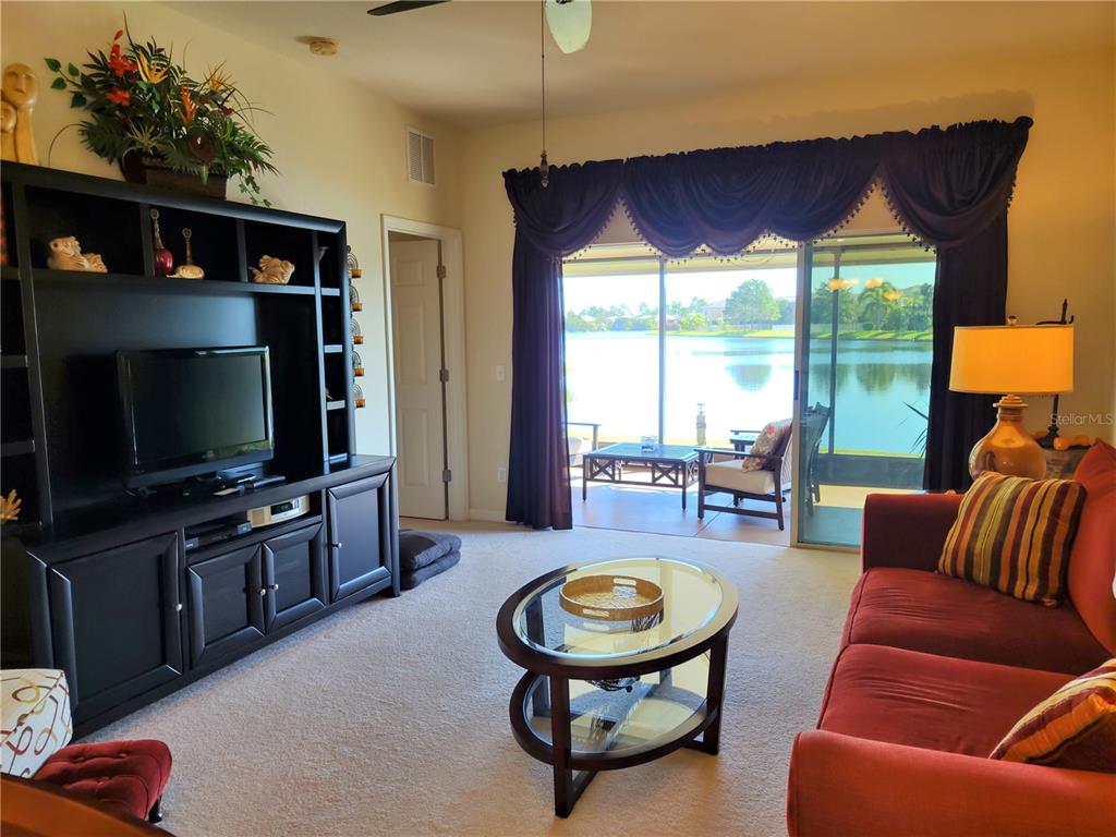 11997 Tempest Harbor Loop Venice, FL 34292 - Photo 9 of 52 a living room with furniture a flat screen tv and a large window