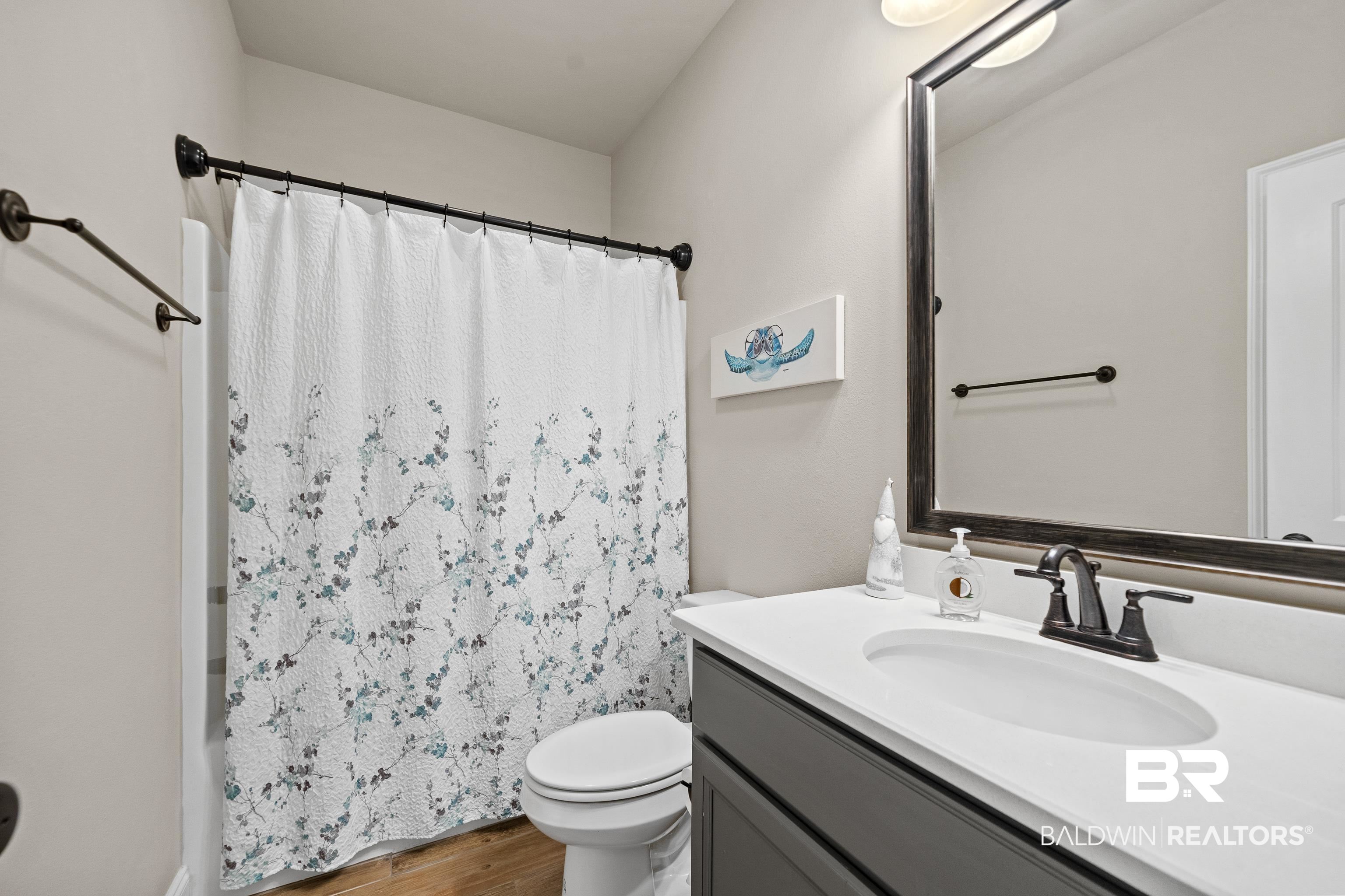 1390 Aldon Street Foley, AL 36535 - Photo 19 of 31 Bathroom with vanity, wood finished floors, and shower / bathtub combination with curtain