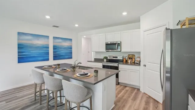 a kitchen that has a sink a counter space and stainless steel appliances