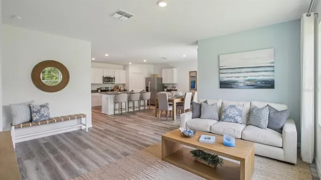 a living room with furniture and a view of kitchen