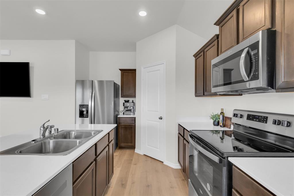 6513 Waterfall Lane Princeton, TX 75407 - Photo 7 of 35 a kitchen with stainless steel appliances granite countertop a sink stove and refrigerator
