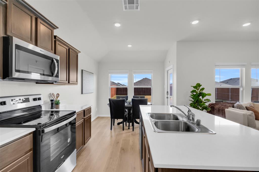 6513 Waterfall Lane Princeton, TX 75407 - Photo 9 of 35 a kitchen with stainless steel appliances granite countertop a sink a stove top oven a counter space and cabinets