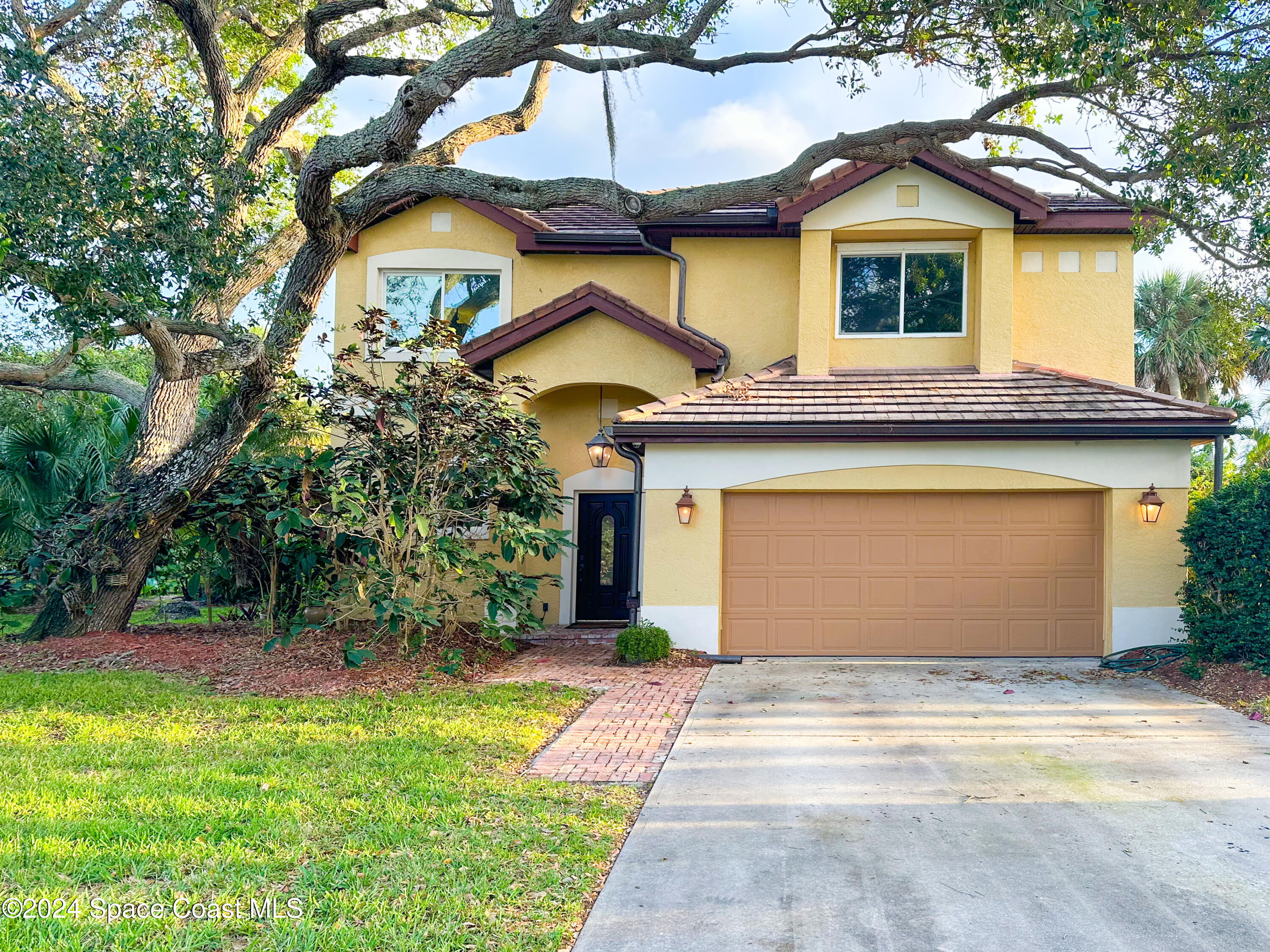 143 Caledonia Drive Melbourne Beach, FL 32951 - Photo 1 of 57 a front view of a house with a yard and garage