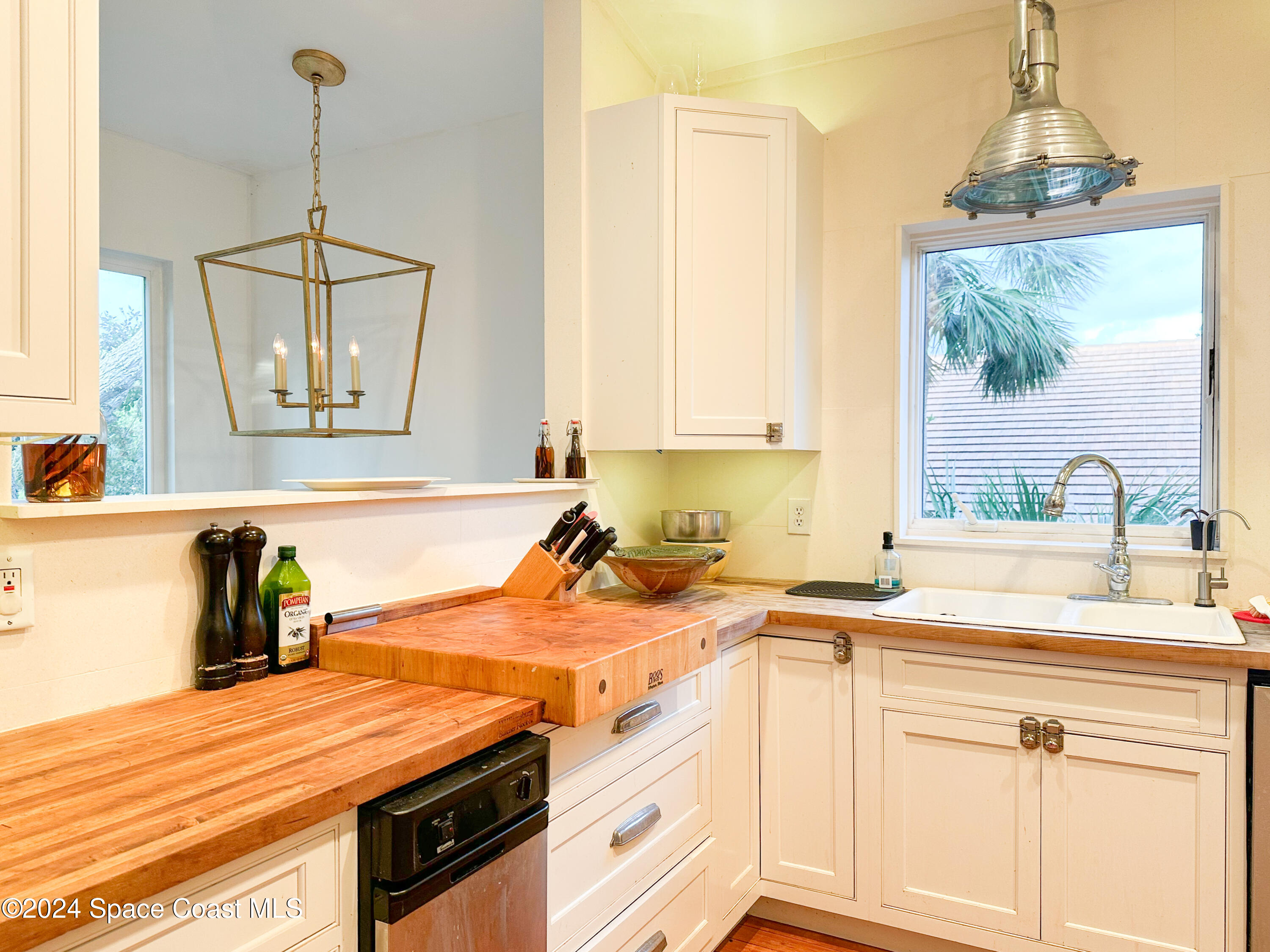 143 Caledonia Drive Melbourne Beach, FL 32951 - Photo 11 of 57 a kitchen with stainless steel appliances granite countertop a sink a stove and a wooden floor
