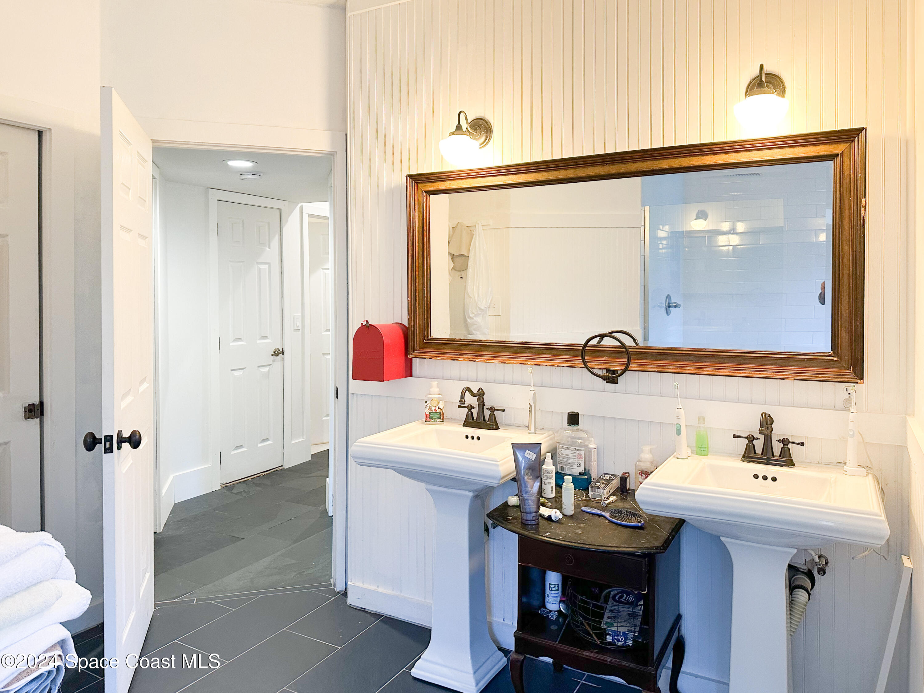 143 Caledonia Drive Melbourne Beach, FL 32951 - Photo 36 of 57 a bathroom with a sink and a mirror