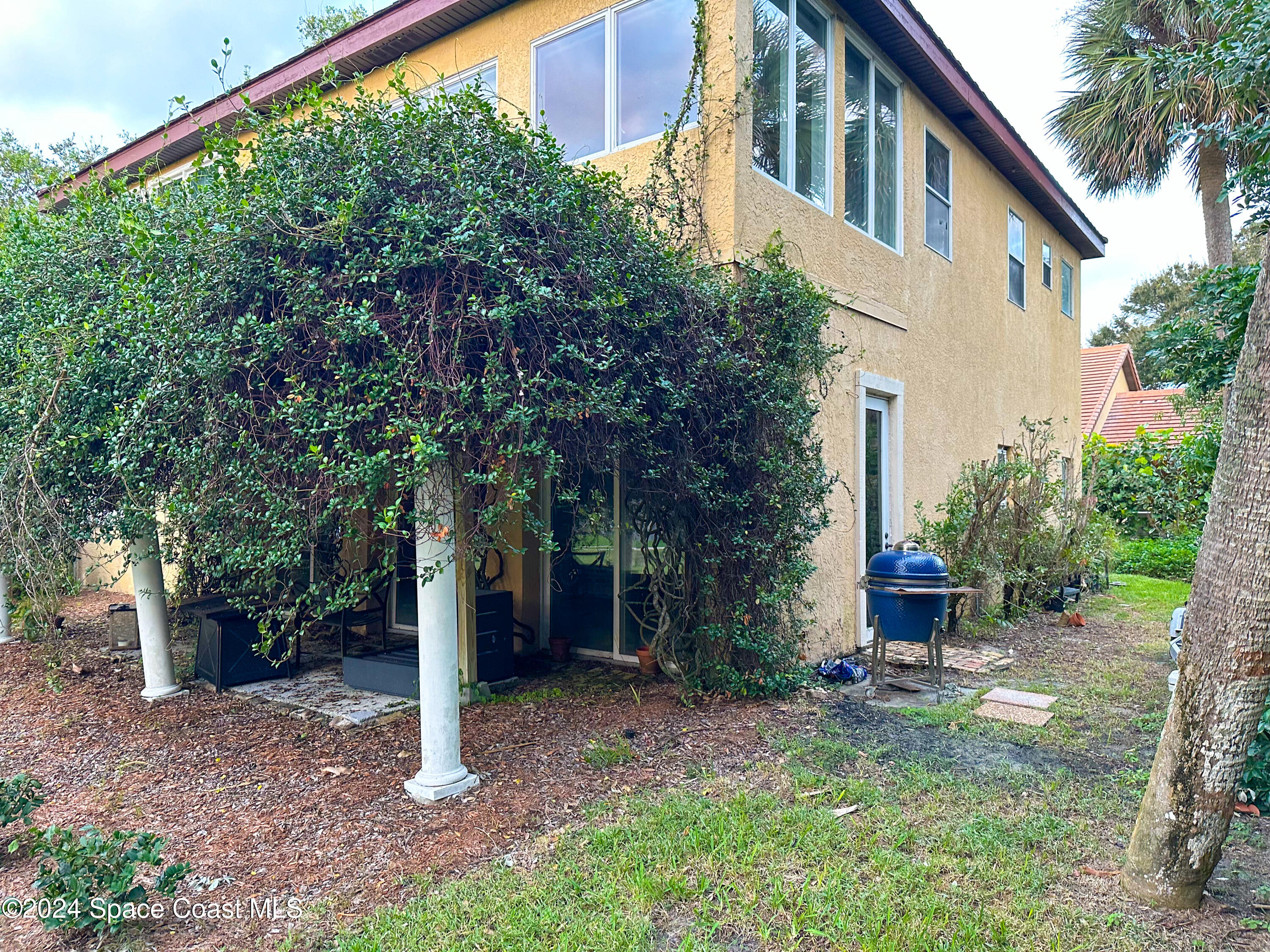 143 Caledonia Drive Melbourne Beach, FL 32951 - Photo 41 of 57 a backyard of a house with plants and outdoor seating