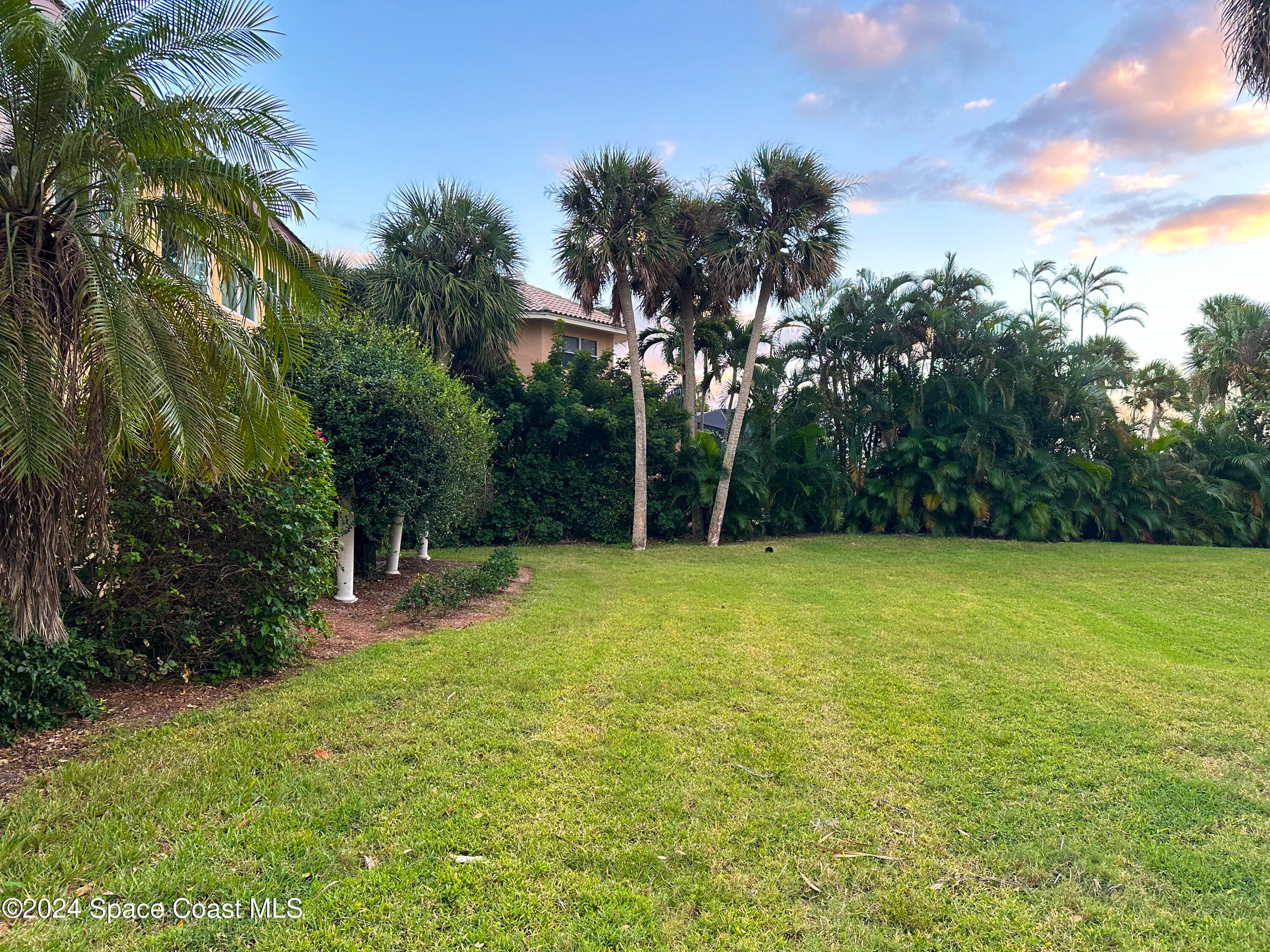 143 Caledonia Drive Melbourne Beach, FL 32951 - Photo 44 of 57 a view of a yard with a house in the background