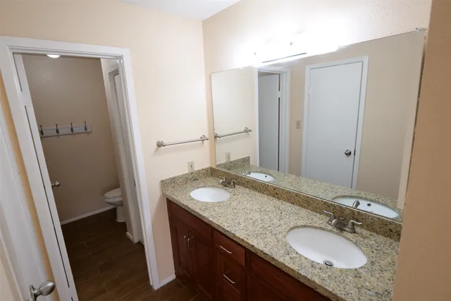 a bathroom with a granite countertop sink and a mirror