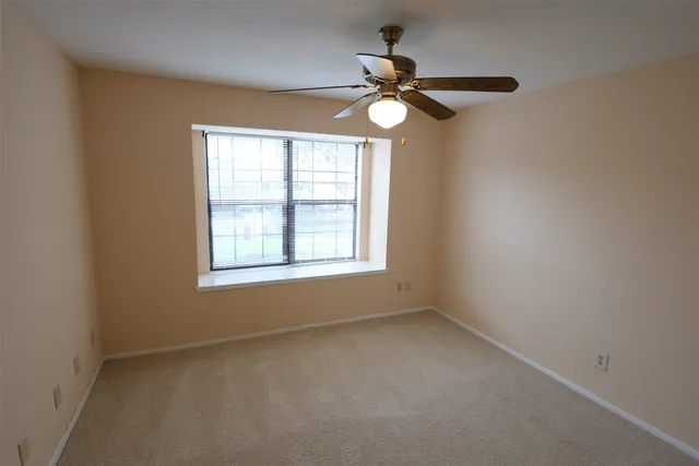 a view of empty room with windows and chandelier fan