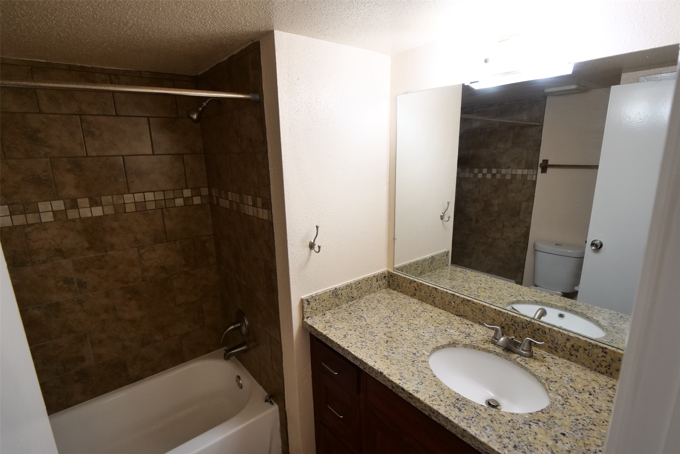 14911 Wunderlich Drive, Unit 2105 Houston, TX 77069 - Photo 21 of 24 a bathroom with a granite countertop sink toilet and shower