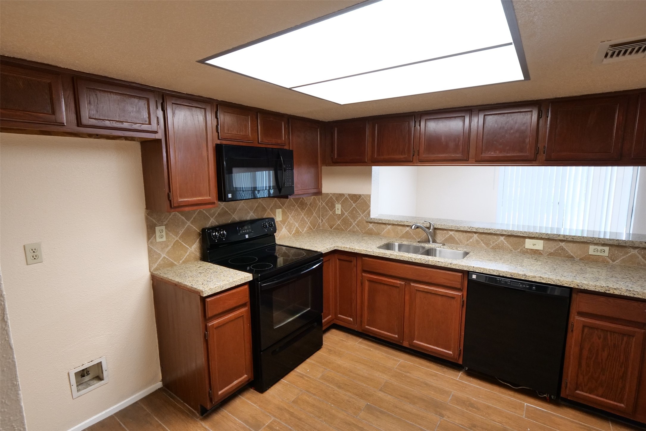 14911 Wunderlich Drive, Unit 2105 Houston, TX 77069 - Photo 4 of 24 a kitchen with stainless steel appliances granite countertop wooden cabinets a sink and dishwasher