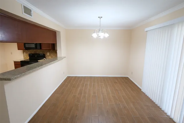 a view of a kitchen with a sink and dishwasher with wooden floor