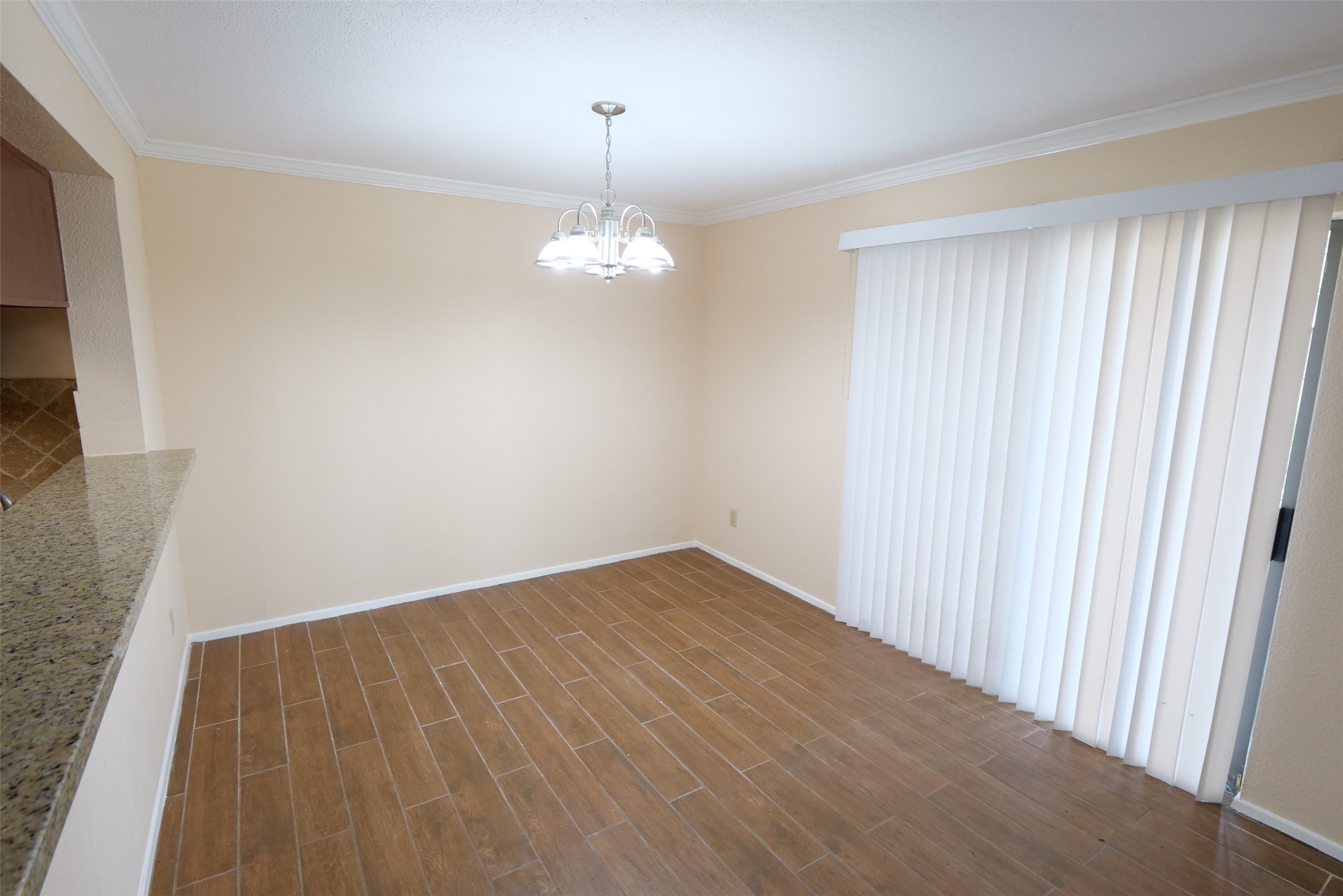 14911 Wunderlich Drive, Unit 2105 Houston, TX 77069 - Photo 10 of 24 an empty room with wooden floor and chandelier