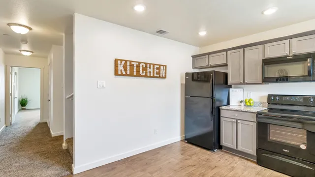 a kitchen with stainless steel appliances a refrigerator sink and microwave