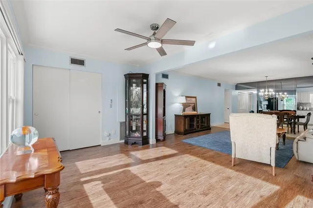 a living room with furniture and a dining table with wooden floor