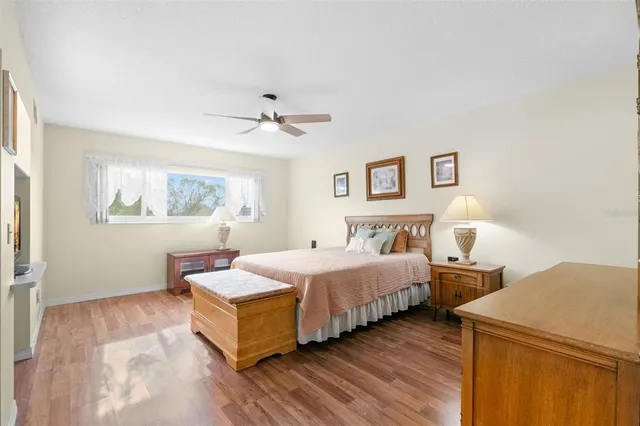 a spacious bedroom with a bed and a painting on the wall