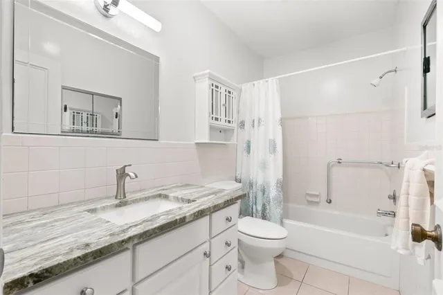 a bathroom with a granite countertop sink a toilet and shower