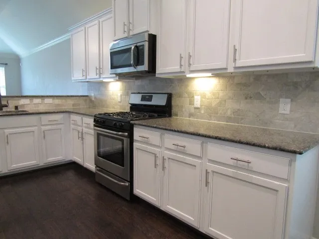 a kitchen with white cabinets and white appliances