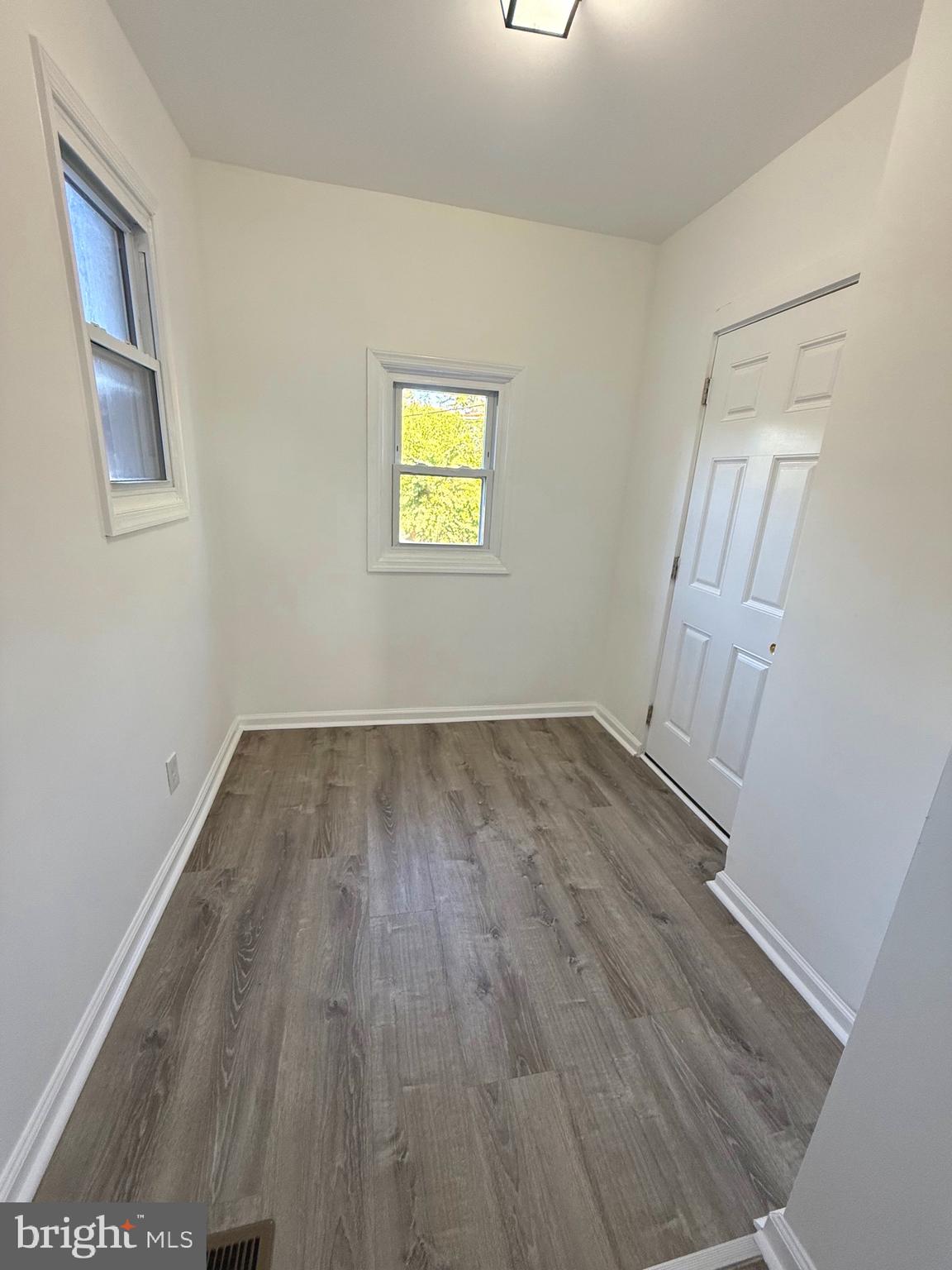 4803 Cordelia Avenue Baltimore, MD 21215 - Photo 11 of 39 an empty room with wooden floor and windows