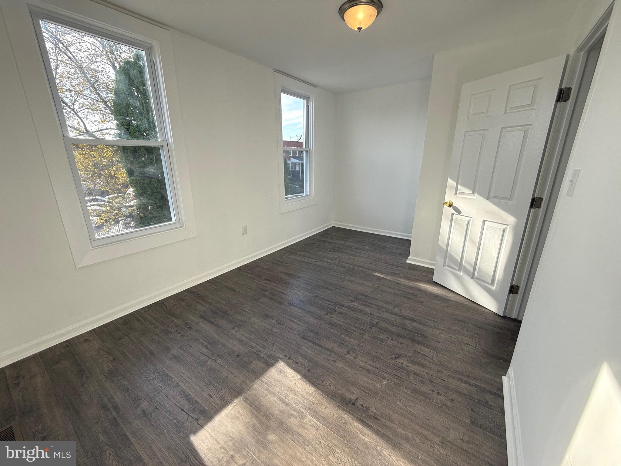 4803 Cordelia Avenue Baltimore, MD 21215 - Photo 13 of 39 a view of an empty room with wooden floor and a window