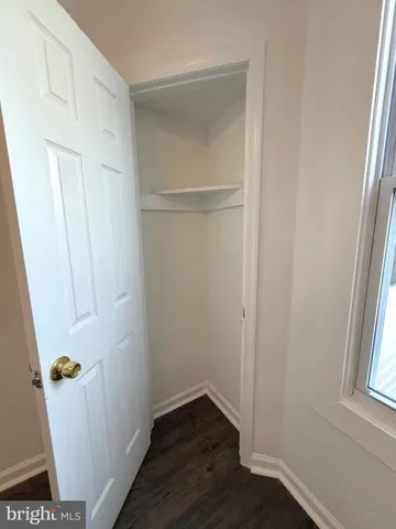 an empty room with wooden floor and a window