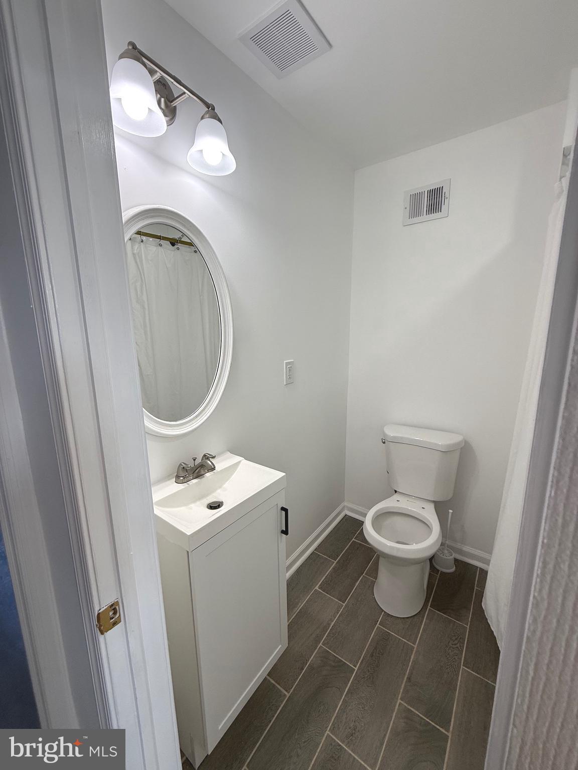 4803 Cordelia Avenue Baltimore, MD 21215 - Photo 25 of 39 a bathroom with a toilet sink and mirror