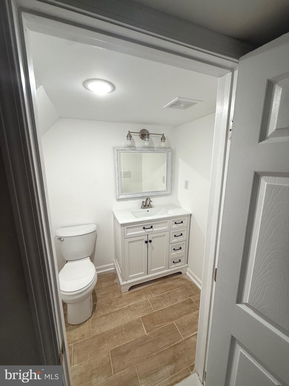 4803 Cordelia Avenue Baltimore, MD 21215 - Photo 32 of 39 a bathroom with a toilet sink and a mirror