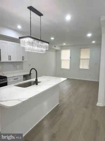 a large kitchen with stainless steel appliances a large counter top a stove and a refrigerator