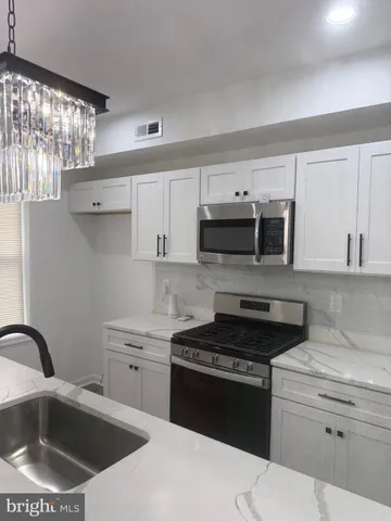 a kitchen with stainless steel appliances granite countertop a sink stove and microwave