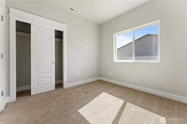 an empty room with windows and closet