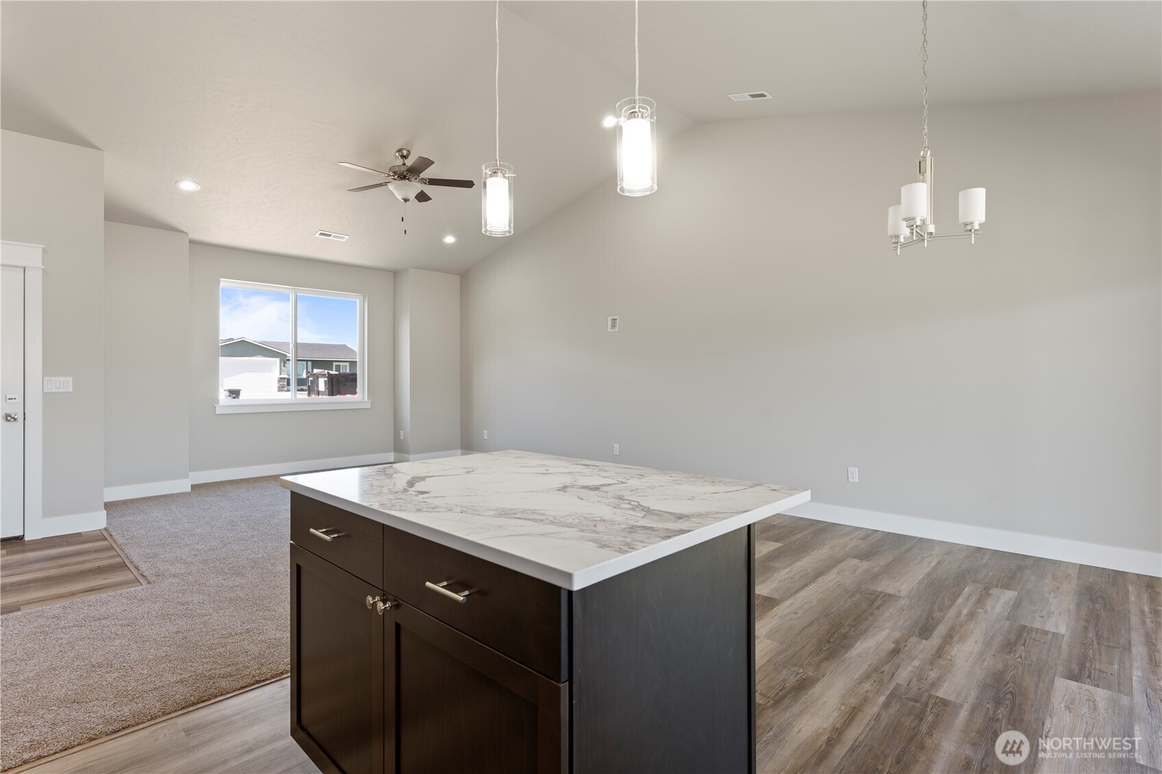 713 O Street Southwest Quincy, WA 98848 - Photo 5 of 34 a hall with kitchen island a wooden floor a ceiling fan and a window