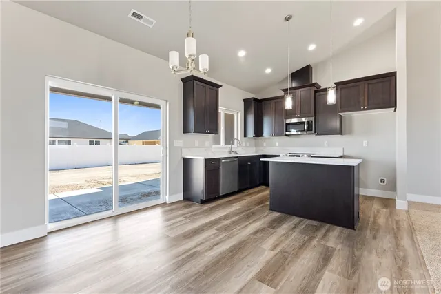 a kitchen with kitchen island a sink stainless steel appliances and cabinets