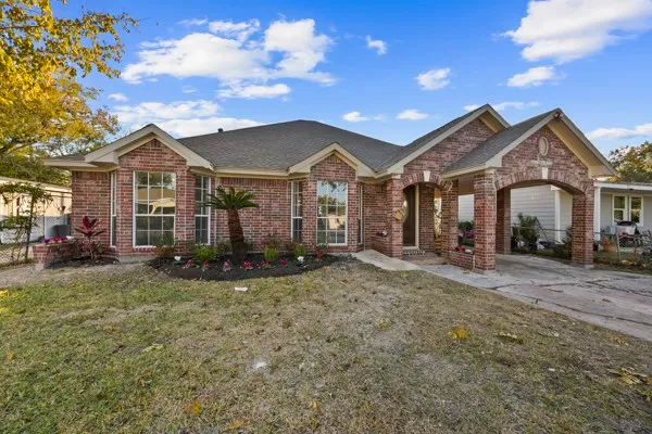 a view of a house with a big yard and large tree
