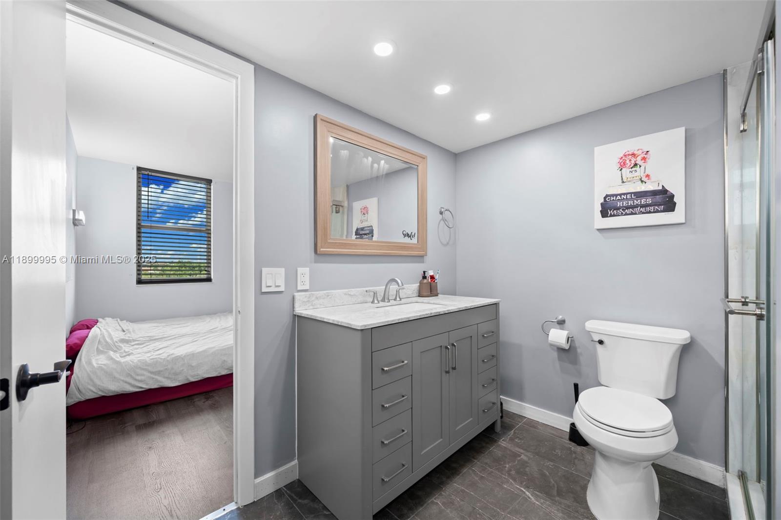 437 Golden Isles Drive, Unit 5J Hallandale Beach, FL 33009 - Photo 16 of 34 a spacious bathroom with a toilet sink and mirror