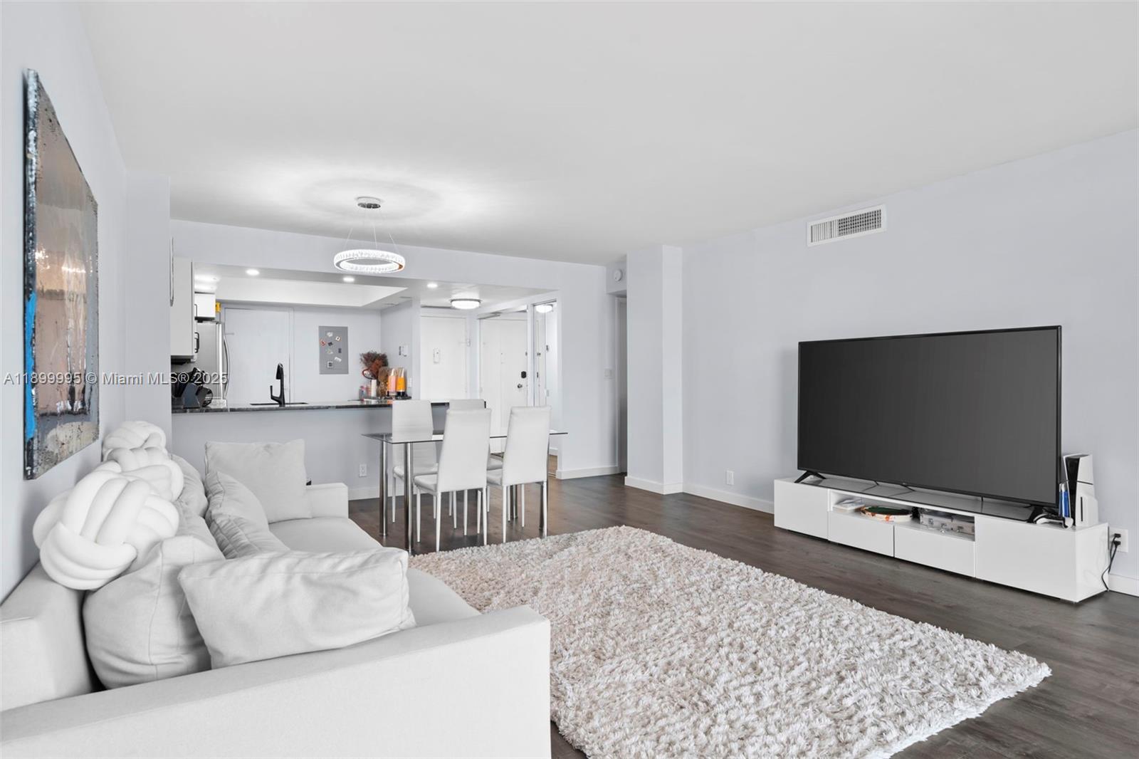 437 Golden Isles Drive, Unit 5J Hallandale Beach, FL 33009 - Photo 7 of 34 a living room with furniture and a flat screen tv